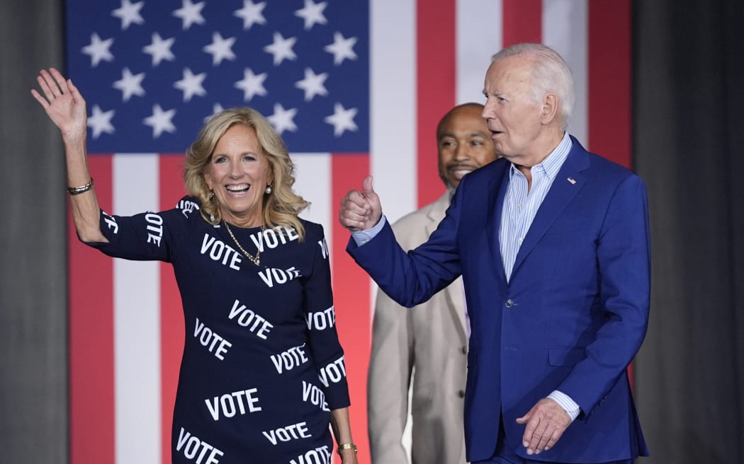 El presidente de los Estados Unidos, Joe Biden, a la derecha, y la primera dama Jill Biden, a la izquierda, caminan hacia el escenario para hablar en un mitin de campaña, con Eric Fitz al fondo, el 28 de junio de 2024 en Raleigh, Carolina del Norte.