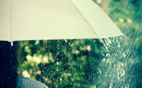 close up a part of the girl who hold on umbrella among Rain drops falling