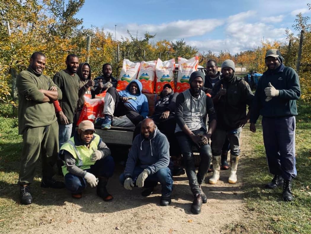 Workers from Vanuatu at Central Organics with produce donated to them after Cyclone Harold