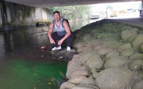 Aaron Tainui at the site of a luminous green discharge into the Huatoki Stream.
