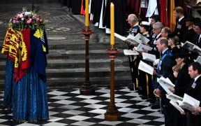 Members of the Royal family and guests sing as the coffin of Queen Elizabeth II, draped in the Royal Standard, lies by the altar during the State Funeral Service for Britain's Queen Elizabeth II, at Westminster Abbey in London on September 19, 2022.