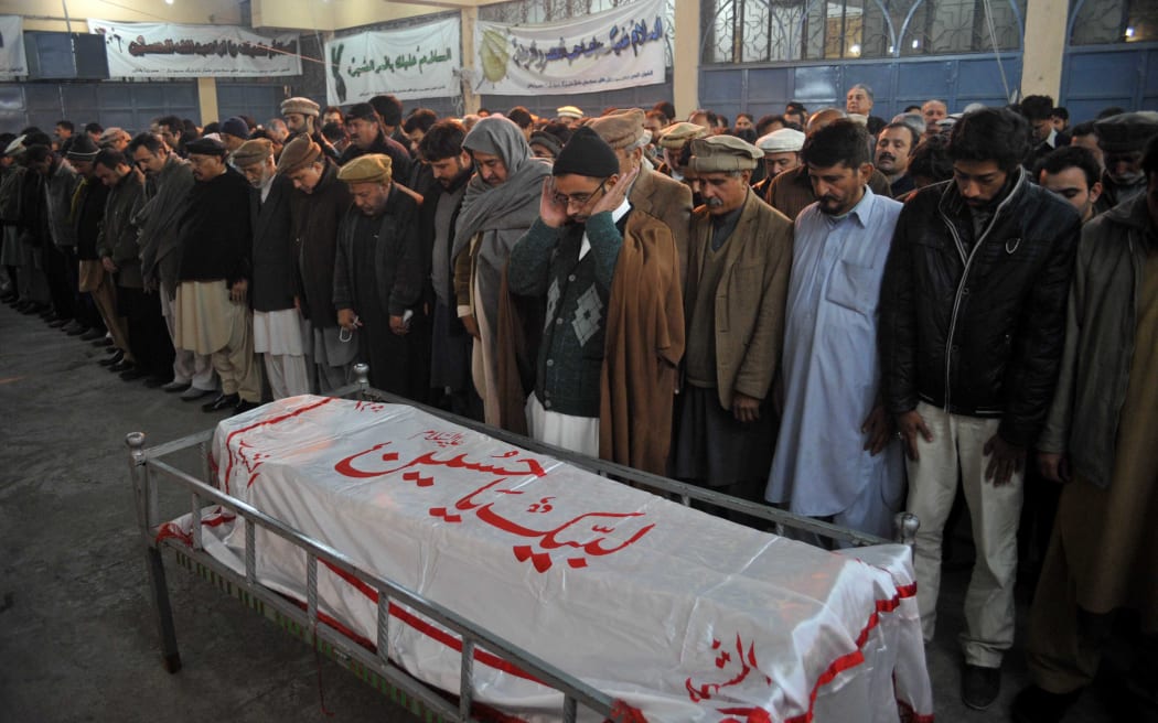 Pakistani mourners pray over the coffin of a student killed in the attack.