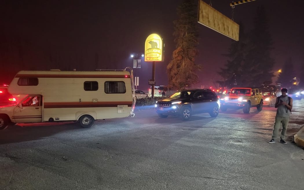 In this image courtesy of Le Minh Khue, visitors evacuate Jasper National Park in Canada on July 22, 2024, due to a wildfire. Authorities in the western Canadian province of Alberta have ordered evacuations of the popular park, famous for its mountain peaks, glaciers and waterfalls, and nearby towns due to approaching forest fires. An alert was sent to tourists late July 22 as well as residents living nearby. (Photo by Le Minh Khue / Le Minh Khue / AFP) / RESTRICTED TO EDITORIAL USE – MANDATORY CREDIT «  AFP PHOTO / Le Minh Khue  » - NO MARKETING NO ADVERTISING CAMPAIGNS – DISTRIBUTED AS A SERVICE TO CLIENTS [ NO ARCHIVE ]