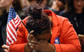 Marta Lunez, supporter of US Democratic presidential nominee Hillary Clinton, reacts to elections results during election night at the Jacob K. Javits Convention Center in New York on November 8, 2016. AFP / DON EMMERT