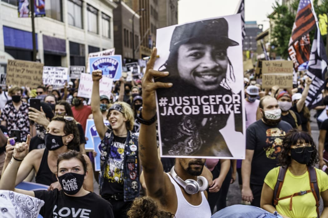 Protesters march near the Minneapolis 1st Police precinct during a demonstration against police brutality and racism on August 24, 2020.