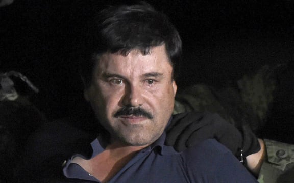 Drug kingpin Joaquin "El Chapo" Guzman is escorted into a helicopter at Mexico City's airport.