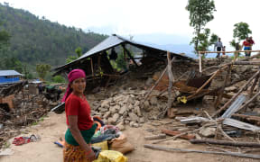 A villager stands near a damaged house at Arupokhari in Gorkha.