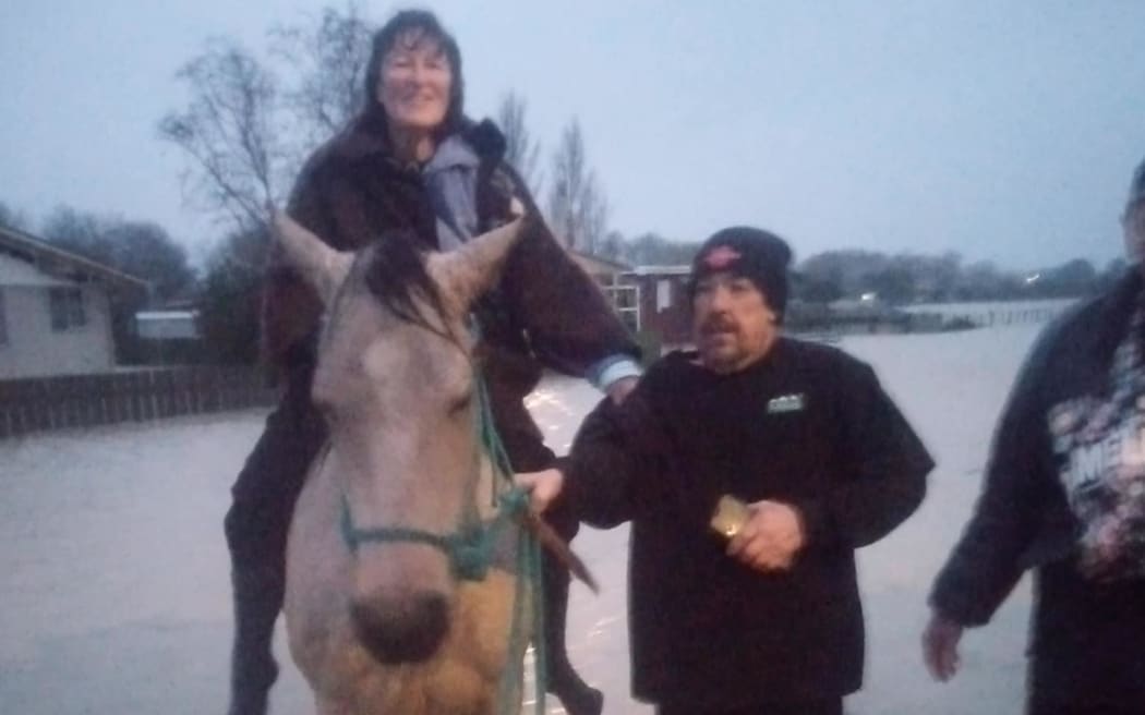 Irelle Lowe being rescued on the back of the local vet's horse.
