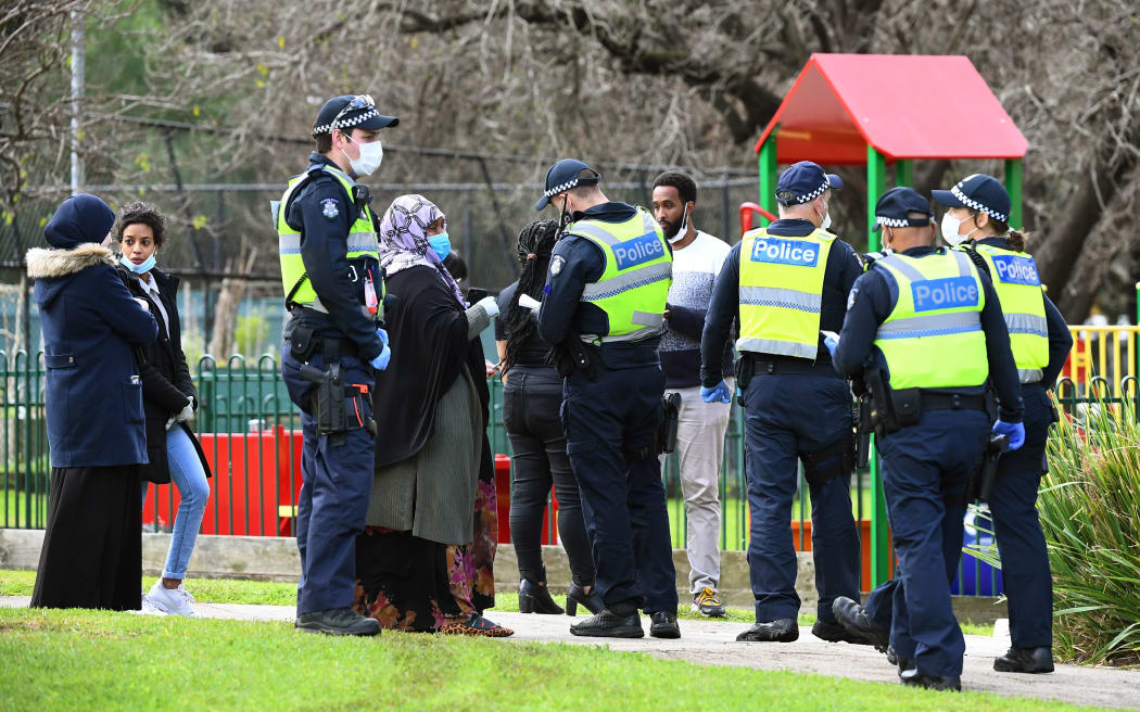 Police speak to people outside one of nine public housing estates locked down due a spike in COVID-19 coronavirus numbers in Melbourne on July 6, 2020.