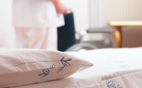 bed at nursing home with wheelchair in background