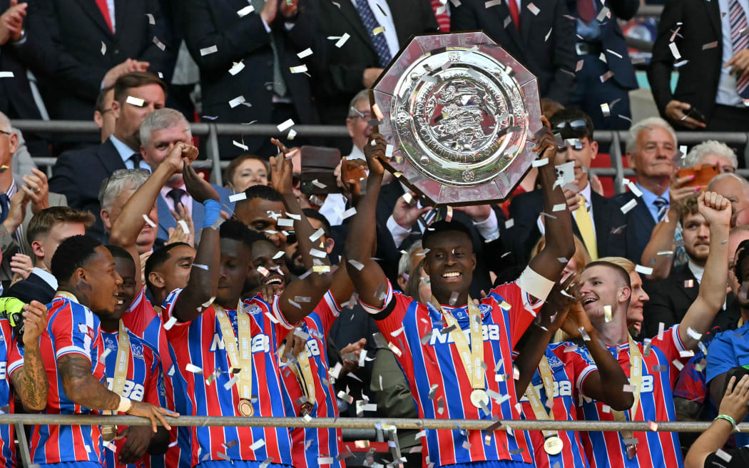 Crystal Palace's English defender Marc Guehi lifts the trophy after Palace win the English FA Community Shield football match against Liverpool, 2025.