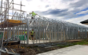 Builders work on one of the hundreds of new houses to spring up in Rolleston since 2011