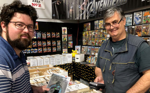 Customer Connor McLay at the Iron Age Comics stand at the Armageddon expo in Auckland, with shop owner David Cryer
