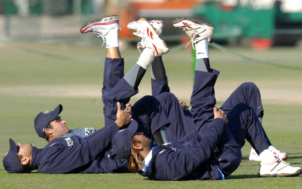 Indian Cricket team trainer Gregory King (C) leads cricketers while stretching during a practice session in the Qaddafi Stadium Lahore, January 6, 2006.
