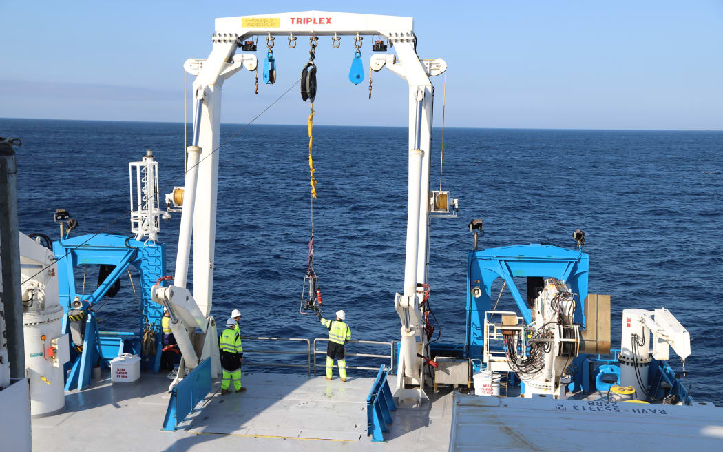 Załoga statku instaluje podwodną kamerę z tylnego pokładu RV Investigator.