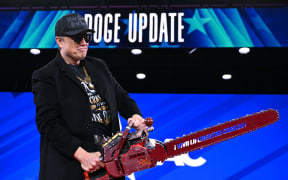 Elon Musk holds a chainsaw reading "Long live freedom, damn it" during the annual Conservative Political Action Conference (CPAC) at the Gaylord National Resort & Convention Center at National Harbor in Oxon Hill, Maryland, on February 20, 2025. The chainsaw was a present to Elon Musk from Argentina's President Javier Milei. (Photo by SAUL LOEB / AFP)