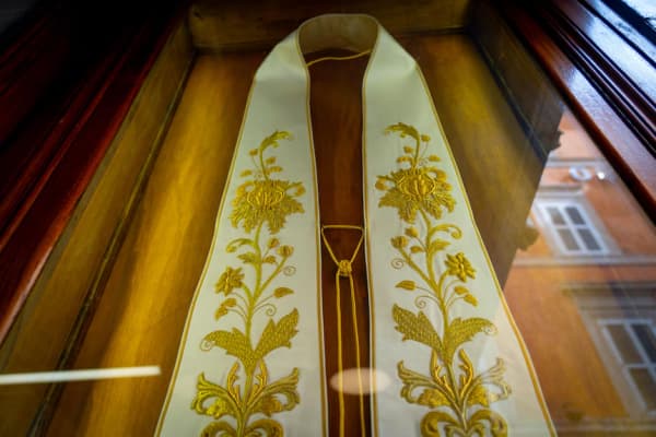A display case with an embroidered stole.