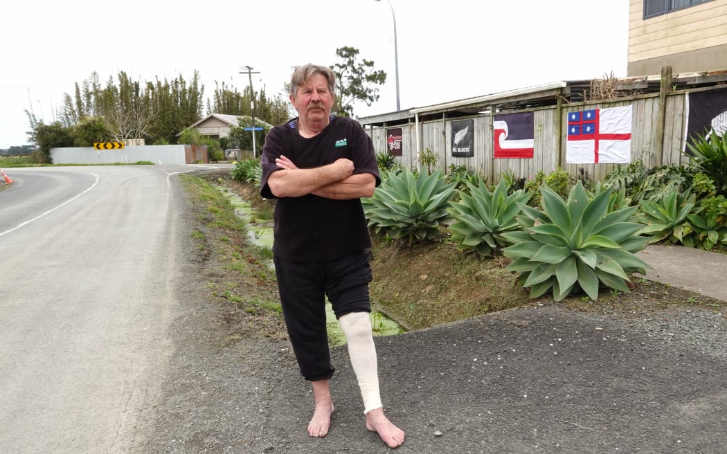 A year after a dog attack that Chris Radich says could have cost his life, the Awanui man still has a bandage on his leg and struggles to walk.