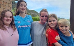 Jamie Ward, centre, and her family were evacuated as flood waters surrounded her Awakino home.