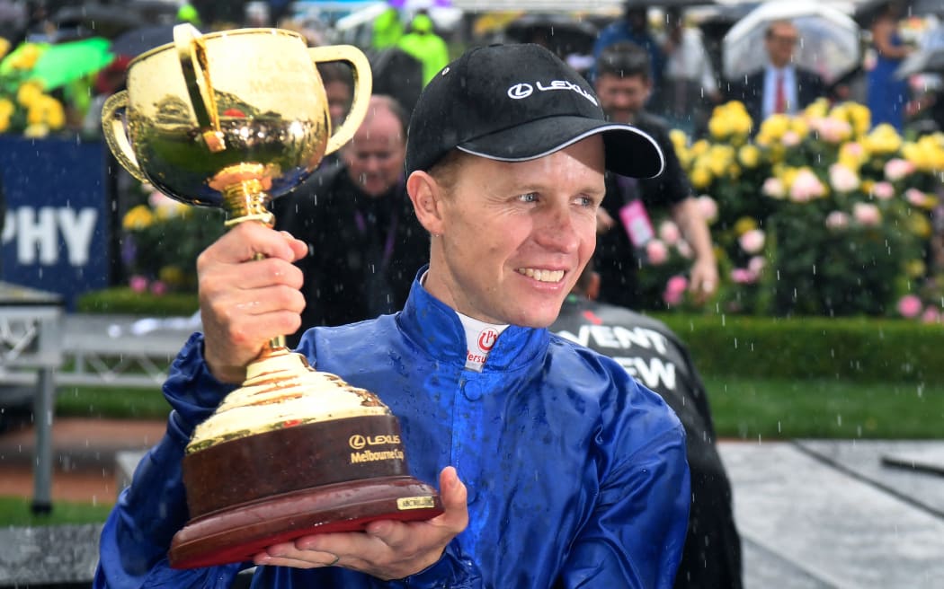 Jockey Kerrin McEvoy holds the Cup in the mounting yard after winning the Melbourne Cup on British horse Cross Counter in Melbourne on November 6, 2018. (Photo by William WEST / AFP) / -- IMAGE RESTRICTED TO EDITORIAL USE - STRICTLY NO COMMERCIAL USE -- - -- IMAGE RESTRICTED TO EDITORIAL USE - STRICTLY NO COMMERCIAL USE --