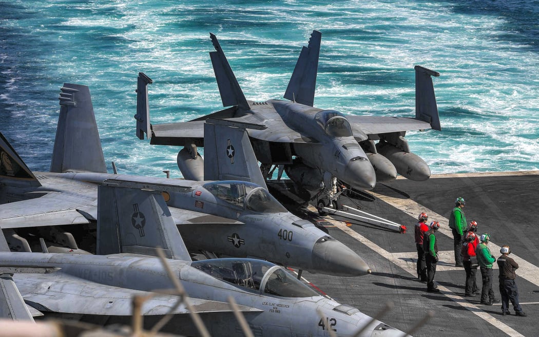 In this photo obtained from the US Department of Defense, US Navy F/A-18 Hornet multirole combat aircraft are pictured on the deck of the aircraft carrier USS Dwight D. Eisenhower (CVN 69) (IKE) transits the Strait of Hormuz on November 26, 2023. The United States said on November 29 that an Iranian drone flew dangerously close to the USS Dwight D. Eisenhower aircraft carrier the day before. The Eisenhower is the centerpiece of one of two carrier strike groups deployed as part of US efforts to deter Iran and its proxy forces in the Middle East from escalating the Israel-Hamas war into a broader regional conflict. (Photo by Kade Bise / US Department of Defense / AFP) / RESTRICTED TO EDITORIAL USE - MANDATORY CREDIT "AFP PHOTO / US DEPARTMENT OF DEFENSE/US NAVY" - NO MARKETING NO ADVERTISING CAMPAIGNS - DISTRIBUTED AS A SERVICE TO CLIENTS - RESTRICTED TO EDITORIAL USE - MANDATORY CREDIT "AFP PHOTO / US Department of Defense/US Navy" - NO MARKETING NO ADVERTISING CAMPAIGNS - DISTRIBUTED AS A SERVICE TO...