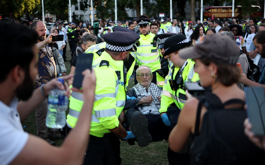 Another protester is carried away by police officers as others film the arrest at the demonstration calling for a recently imposed ban on the group Palestine Action to be lifted.