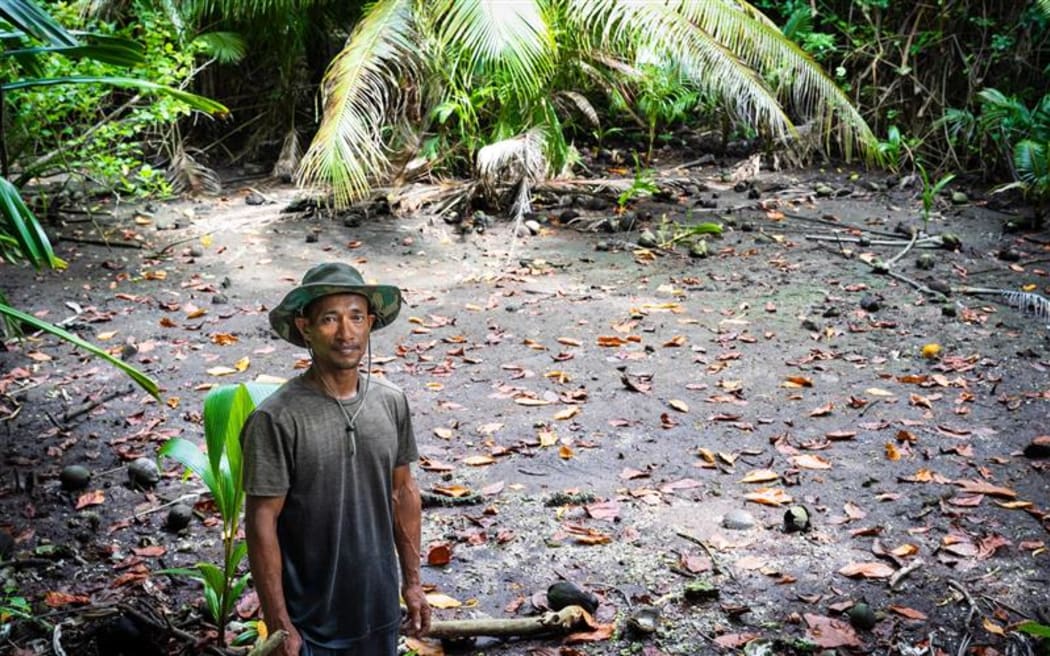 Kapingamarangi resident Rubino and his old taro pit which was destroyed by seawater in January 2024. It was manually dug out.