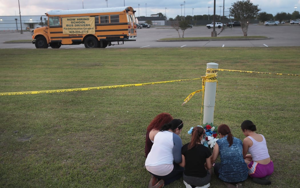 Mourners say a prayer after leaving flowers in front of Santa Fe High School on May 19, 2018 in Santa Fe, Texas.