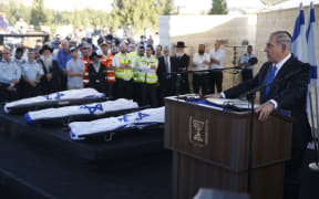 Israeli Prime Minister Benjamin Netanyahu (R) eulogizes at the funeral for the three Israeli teens.