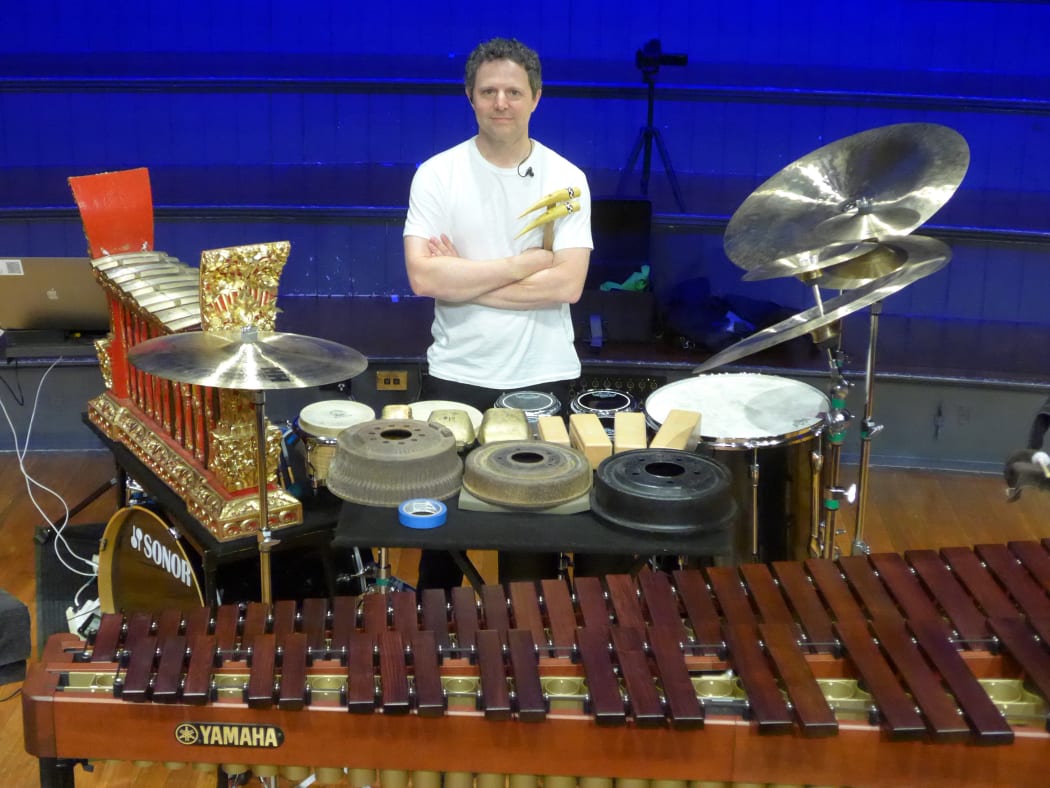 percussionist Justin DeHart posing behind a battery of his instruments