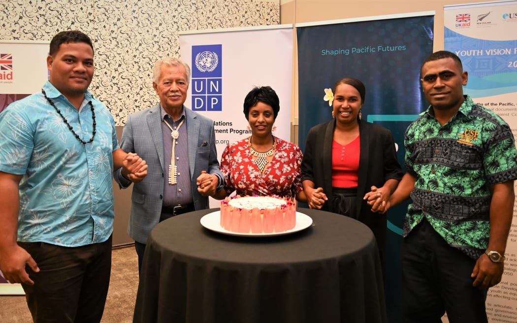 Simon Kofe, Henry Puna and Yemesrach Workie (left to right) join hands with two others for the launch of the Pacific Youth Advisory Board on Governance.