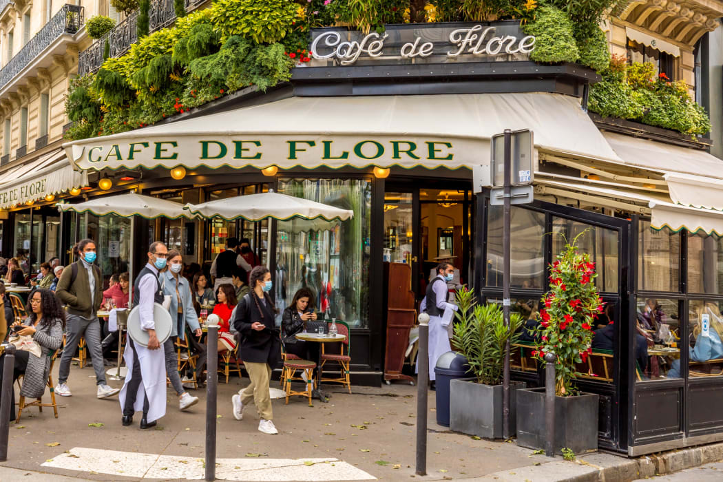 Waiters wear masks at a famous Parisian cafe on 19 May, 2021, a day after lockdown due to Covid-19.