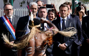 French President Emmanuel Macron (R) watches the Haka performance in Noumea.