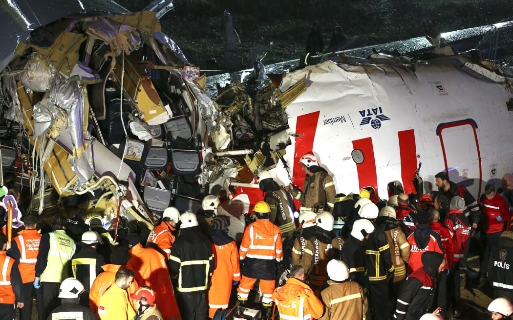 Health teams and fire brigade crews conduct operation at debris of a passenger plane after skidded off the runway in Istanbul Sabiha Gokcen International Airport, breaking into two, on February 05, 2020 in Istanbul, Turkey.