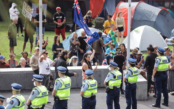 Police form a line around protesters at Parliament.