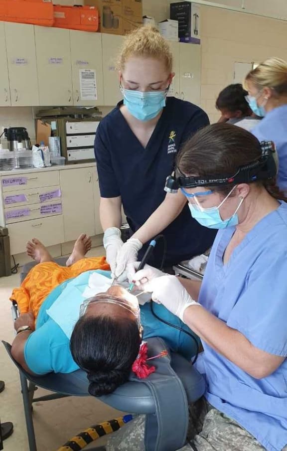 Dental Hygienist Sergeant Renee Mudgway (right), and Dental Assistant Lance Corporal Nadine Nitschke, treat a patient in Samoa