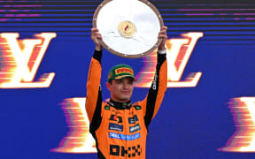 First-placed McLaren's British driver Lando Norris celebrates on the podium with his trophy after winning the Australian Formula One Grand Prix at Albert Park Circuit in Melbourne on March 16, 2025. (Photo by WILLIAM WEST / AFP) / -- IMAGE RESTRICTED TO EDITORIAL USE - STRICTLY NO COMMERCIAL USE --