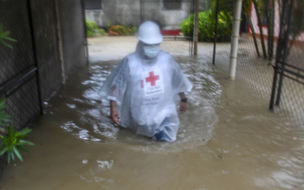 A member a Guatemalan Red Cross wades through a flooded street due to the heavy rains caused by Hurricane Eta, now degraded to a tropical storm, in Puerto Barrios, Izabal 310 km north Guatemala City on November 5, 2020. -