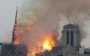 Flames engulf a spire of the medieval  Notre-Dame Cathedral.