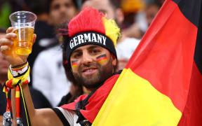 A German fan holds a non-alcoholic beer during the 2022 World Cup in Qatar