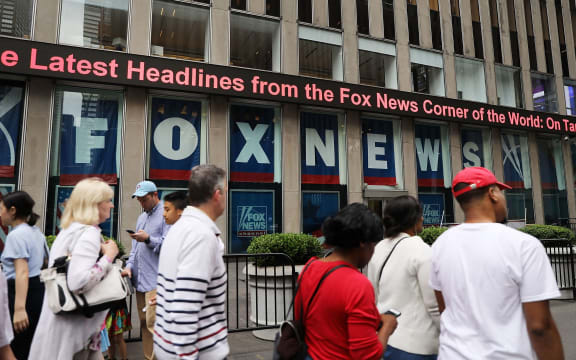 People walk by the headquarters of 21st Century Fox on June 13, 2018 in New York City. Comcast, the giant cable operator, on Wednesday officially made a $65 billion all-cash bid for the majority of Fox.