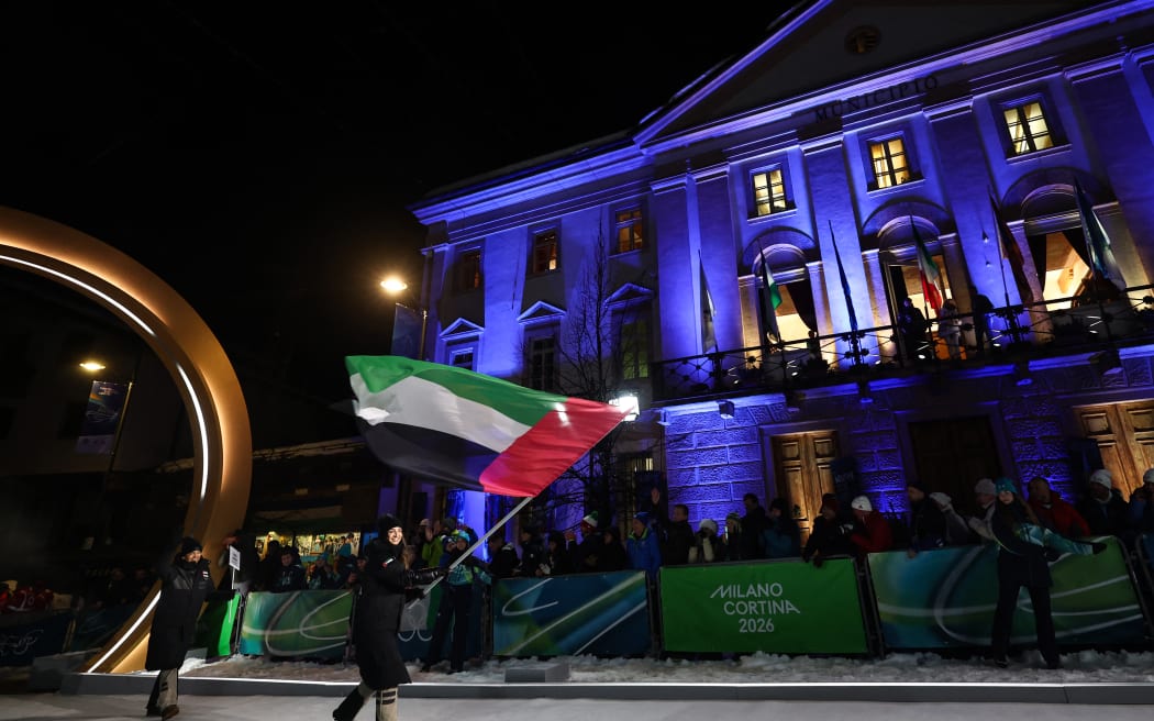 United Arab Emirates's flag bearer Piera Hudson parades during the opening ceremony of the Milano Cortina 2026 Winter Olympic Games in Cortina d'Ampezzo, northern Italy, on February 6, 2026. (Photo by Franck FIFE / AFP)