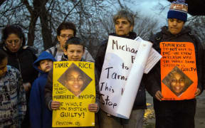 People display sigs at Cudell Commons Park in Cleveland, Ohio, during a rally for Tamir Rice.