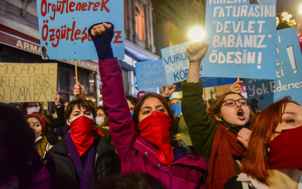 Demonstrators in Turkey chant slogans and hold placards during a protest against gender-based violence.