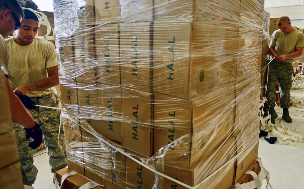 Airmen from the 8th Expeditionary Air Mobility Squadron of the US Air Force package halal meals for a humanitarian airdrop mission over Iraq in August.
