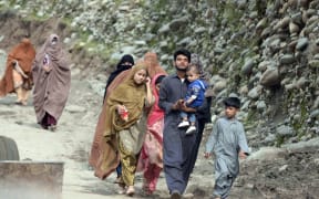 SWAT, PAKISTAN - AUGUST 29: Displaced people walk to a safer area following the deadly climate catastrophe in the Swat Valley, Khyber Pakhtunkhwa province, Pakistan on August 29, 2022. Pakistan's flooding emergency threatens to leave a third of the country underwater while flash floods triggered by destructive monsoon rains have killed more than 1,000 people and injured thousands more since June. Zubair Abbas / Anadolu Agency (Photo by Zubair Abbas / ANADOLU AGENCY / Anadolu Agency via AFP)