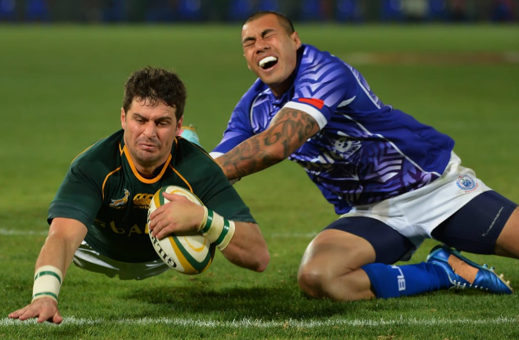 Morne Steyn of South Africa scores against Samoa's Tusi Pisi, Pretoria, 2013.