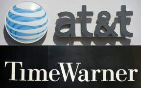 An AT&T cellphone store (TOP) in Springfield, Virginia, on October 23, 2014, and the Time Warner company logo on the front of the headquarters building, 24 November, 2003 in New York. 
A US judge cleared the AT&T merger with Time Warner with no conditions on June 12, 2018.