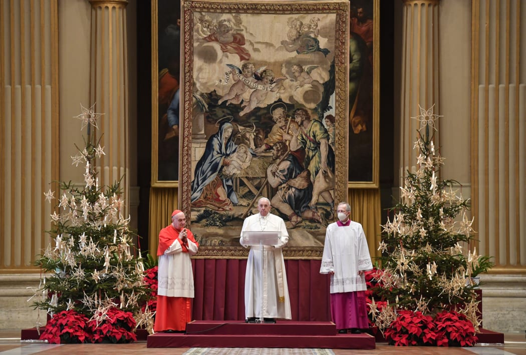 This handout photo taken on December 25, 2020, and released by the Vatican press office, the Vatican Media, shows Pope Francis (C) delivering his streamed Urbi et Orbi blessing from the Vatican Blessing hall.