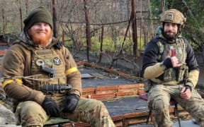 Jordan O'Brien (left), a former New Zealand soldier fighting in Ukraine, relaxes with a colleague.
